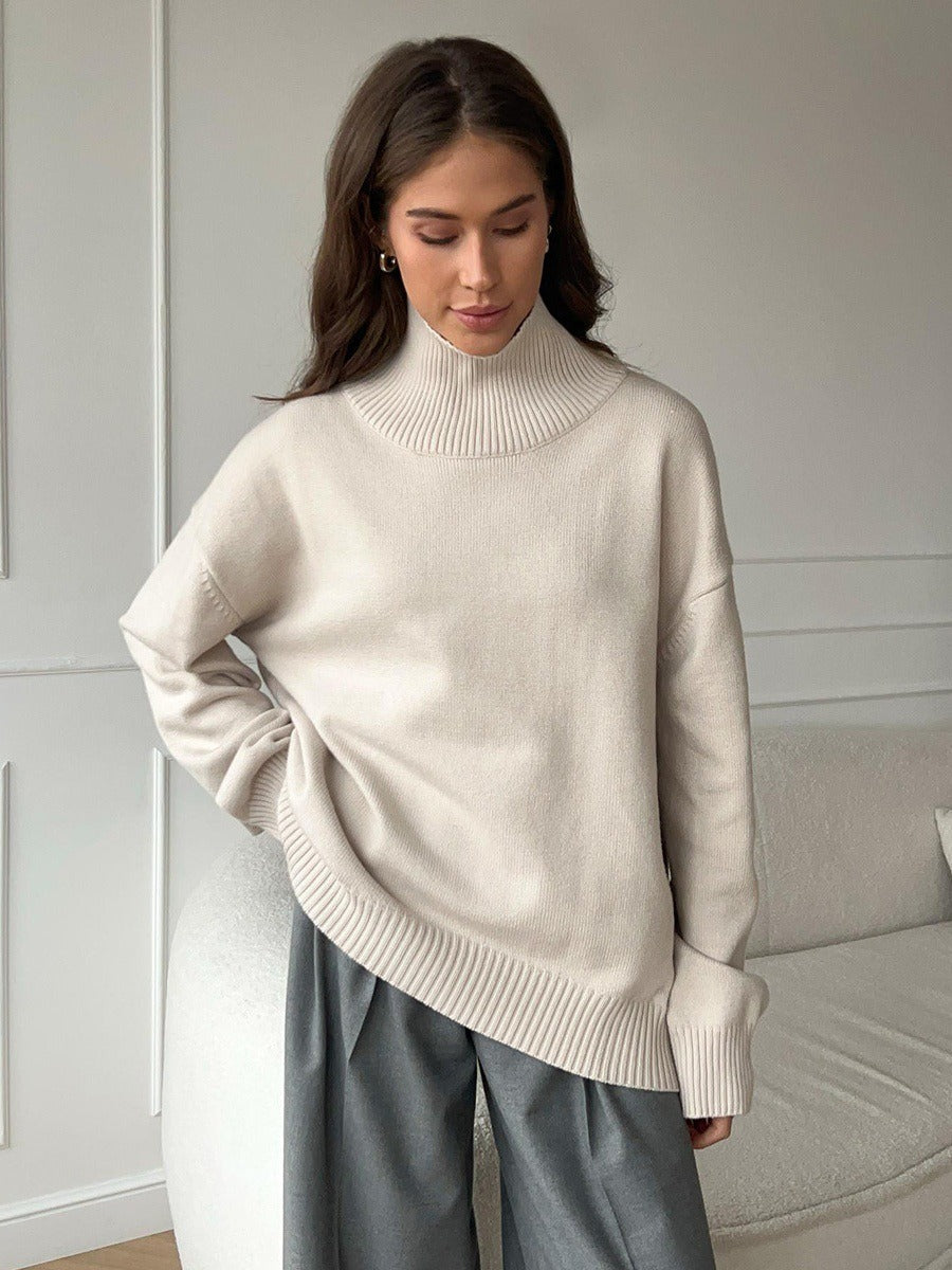 Loose turtleneck knit sweater in off-white, long sleeves, relaxed fit.