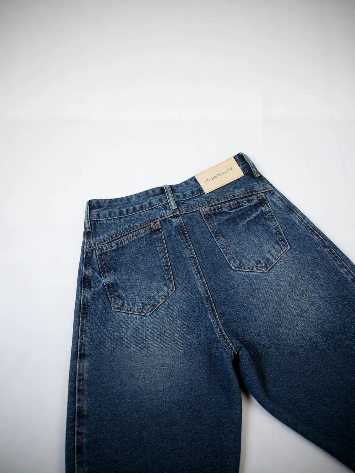 Women's dark blue denim jeans close-up, mid-rise waistband with belt loops and back pocket