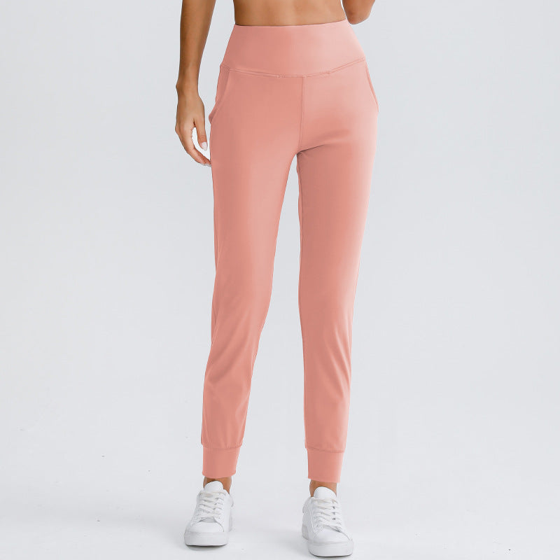 Women's pink yoga pants with elastic waistband and tapered ankle-length fit