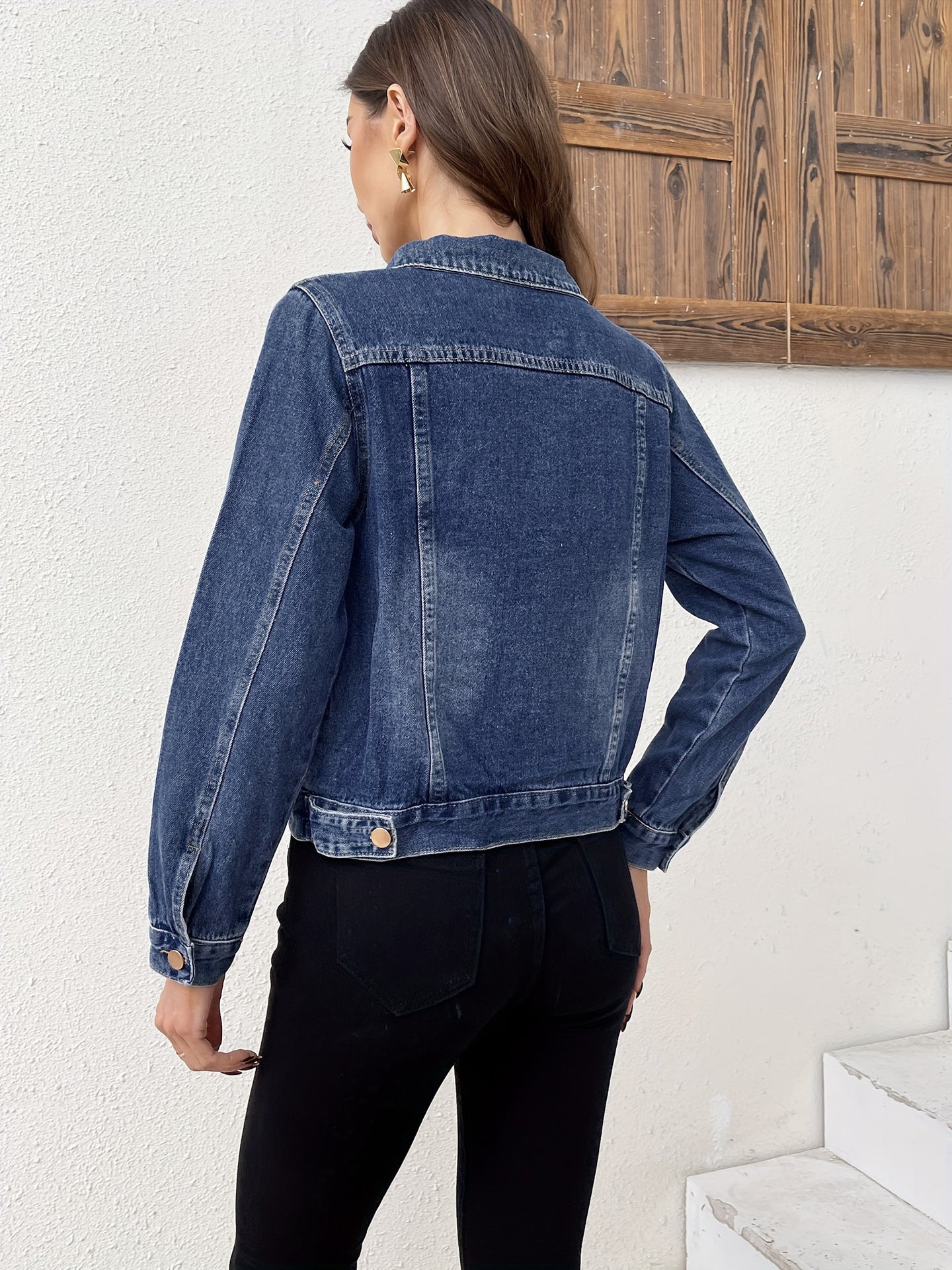 Women's blue denim jacket back view with copper buttons and cropped hem