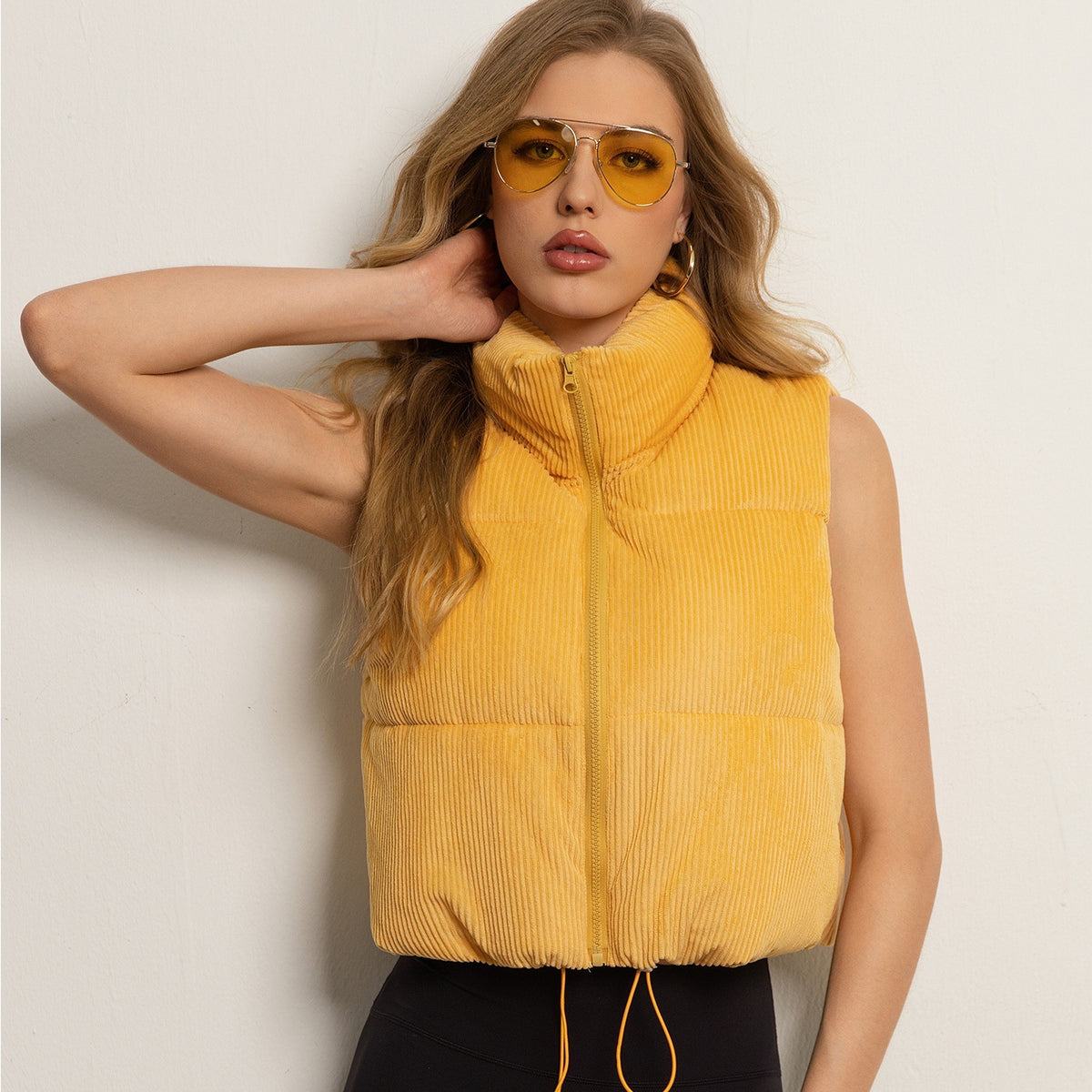 Women’s sleeveless yellow puffer vest with stand collar and front zipper