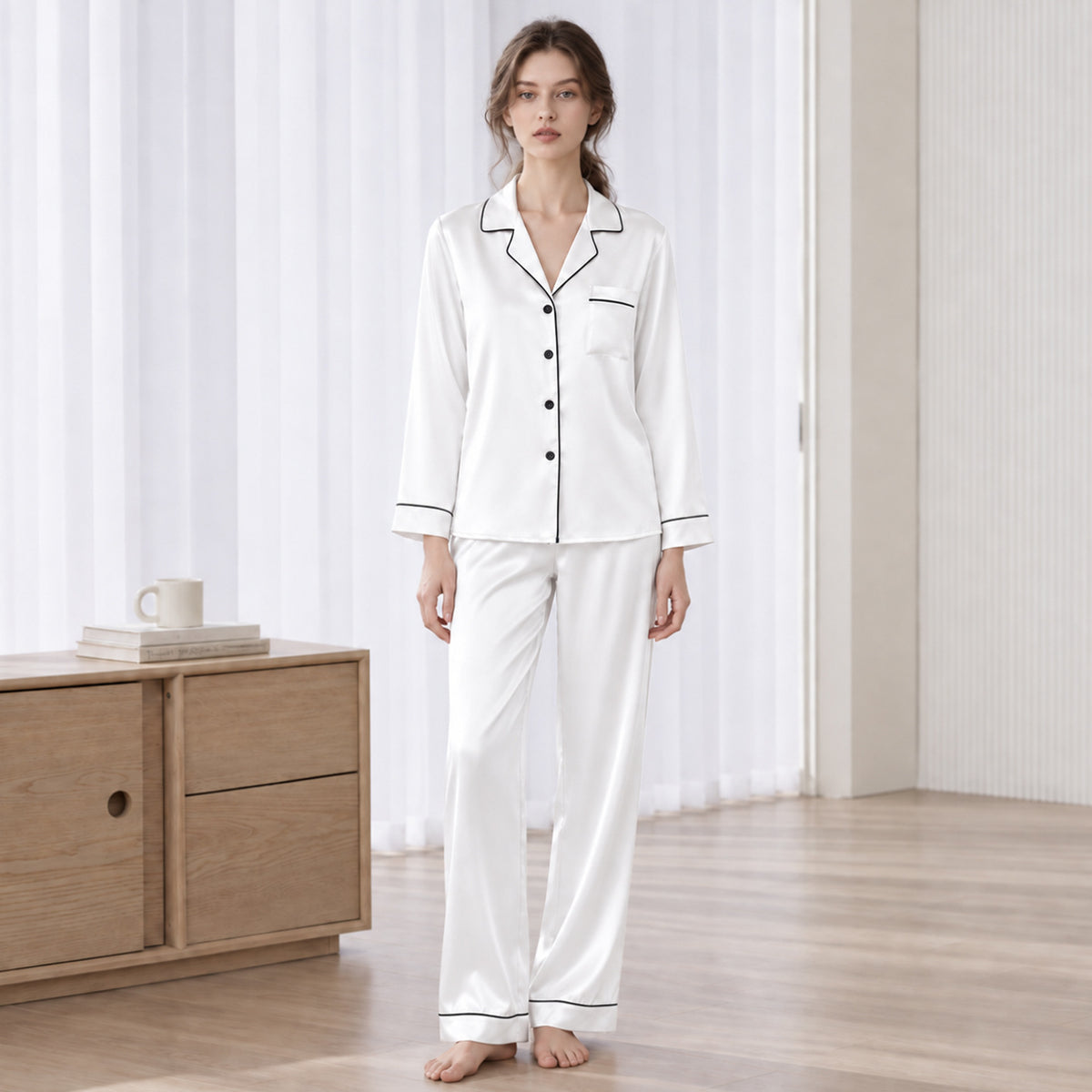 White silk pajama set with long-sleeve button-up top and matching long pants, contrast trim
