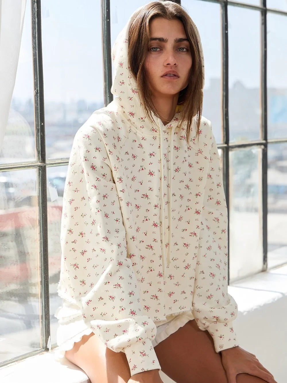 Apricot floral print pullover hoodie with drawstring hood, long sleeves, and ruffled cuffs