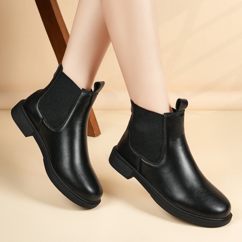 Pair of black chelsea ankle boots with elastic side panels and lug sole