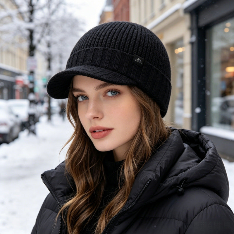 Black ribbed knit beanie with folded brim and small logo patch