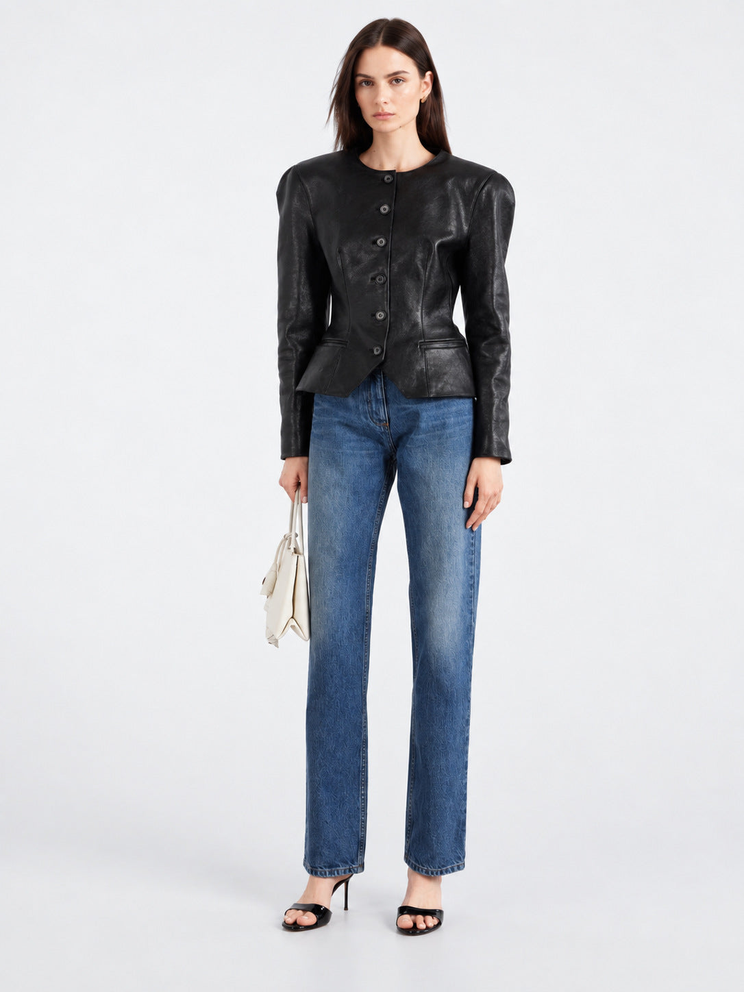Women’s black leather jacket with button front and peplum waist, long sleeves.