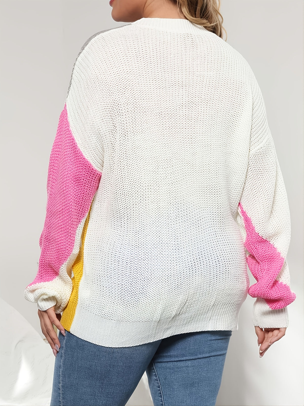 Plus size knit sweater, back view in white with pink sleeves and contrast color blocks