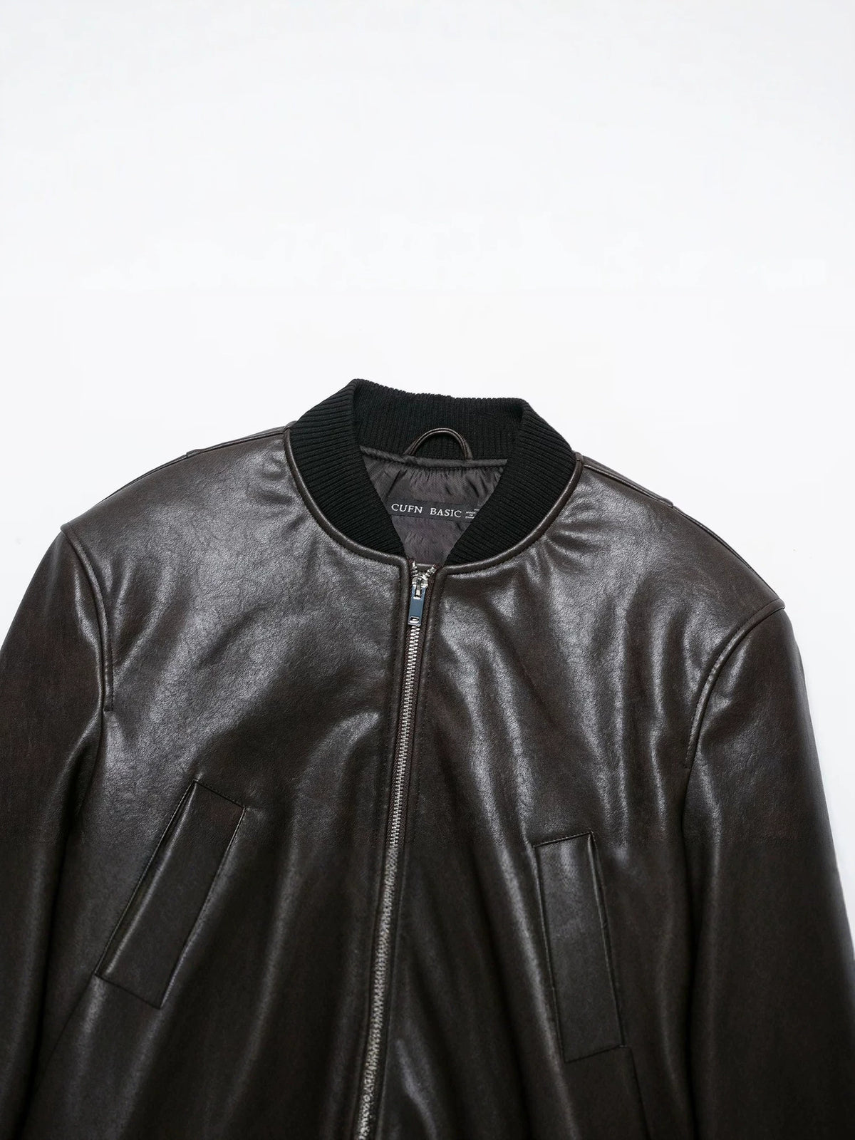 Close-up of the bomber jacket's ribbed collar, front zipper, and slanted pockets