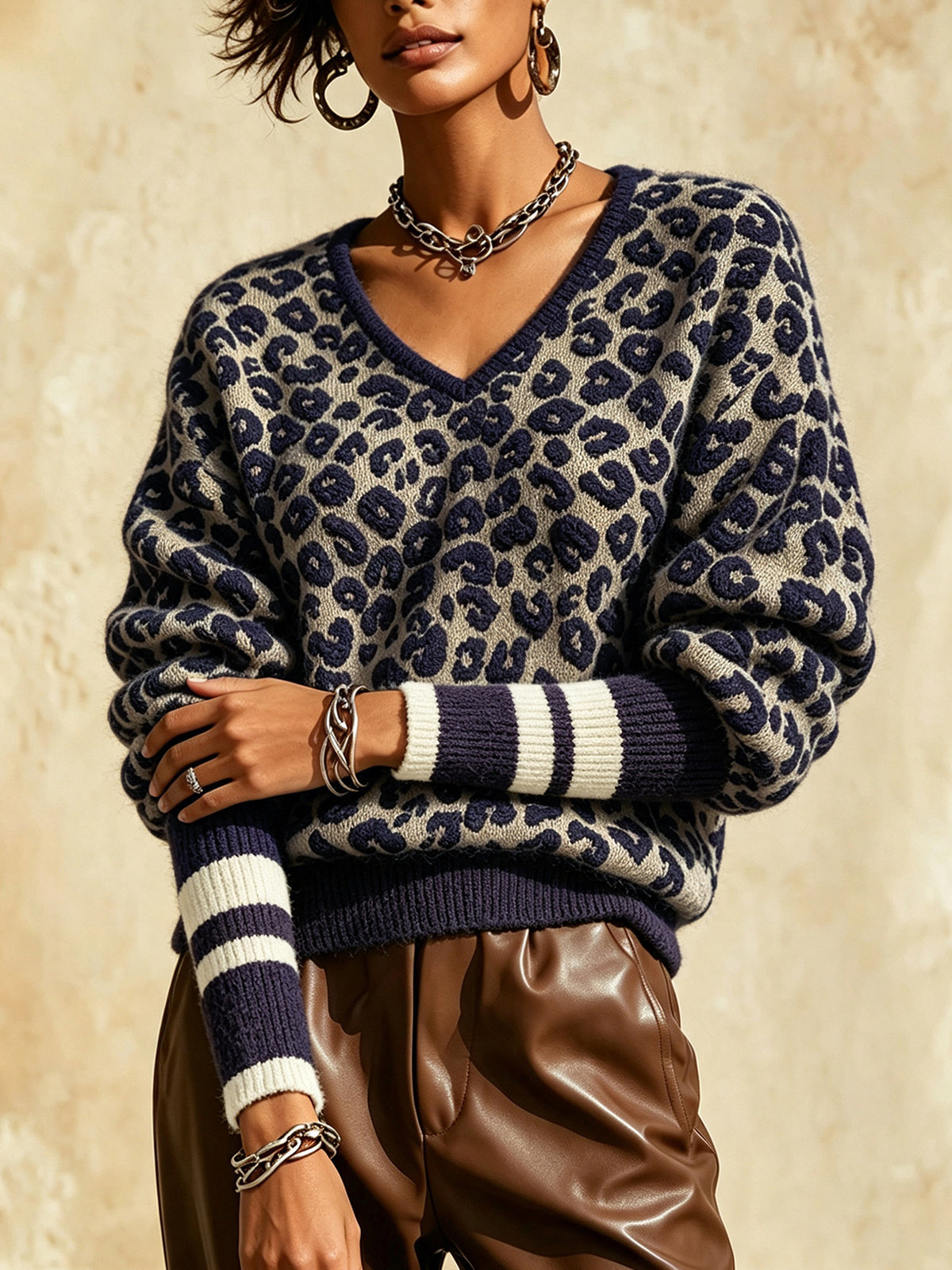 Blue leopard print V-neck knit sweater with striped cuffs and ribbed hem