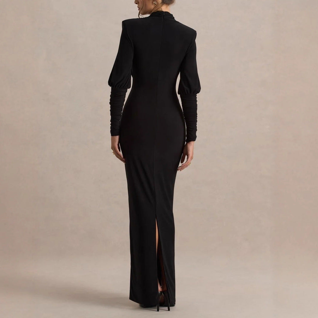 Black long-sleeve maxi dress with center-back slit and draped waist, back view