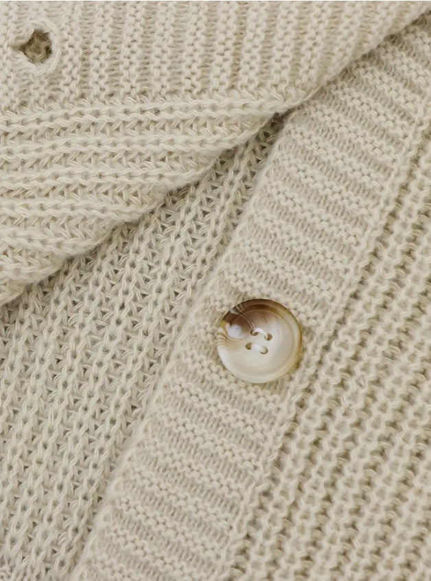 Off-white knitted cardigan close-up: ribbed texture and round button