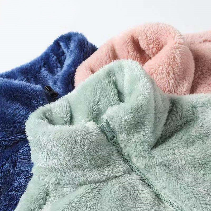 Double-sided fleece jacket, close-up view in dark blue, pink, mint, and light gray