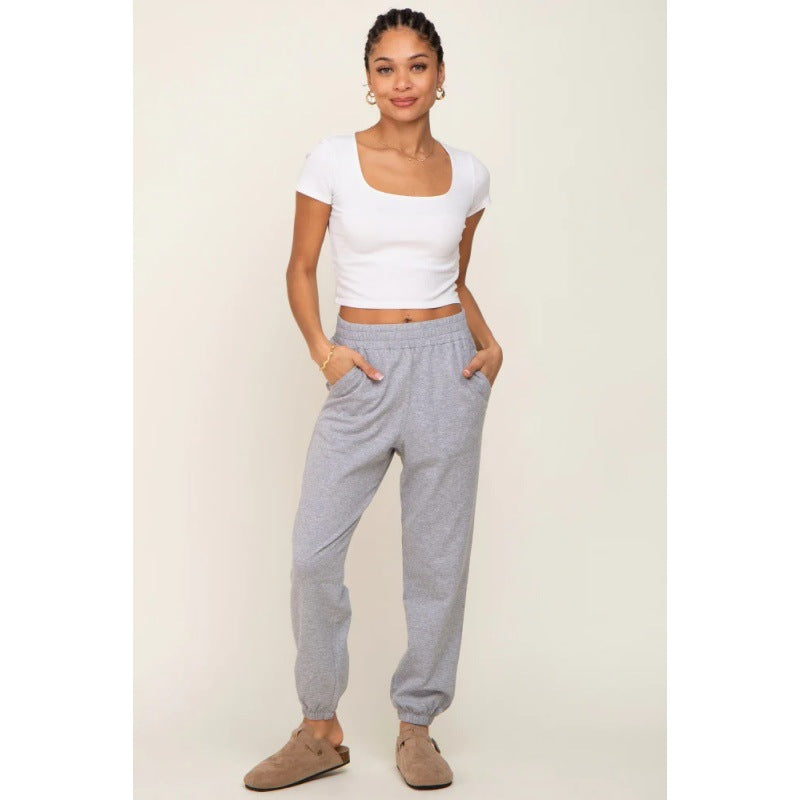 Grey jogger sweatpants with high-rise elastic waist, tapered legs, and cuffed hems