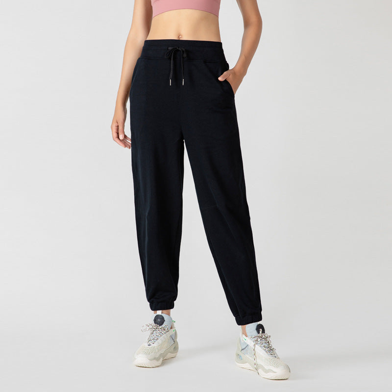 Black jogger pants with drawstring waist, side pockets, and elastic ankle cuffs