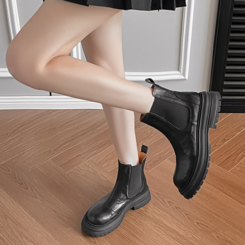 Black leather platform Chelsea boots with elastic side panels and lug sole on model