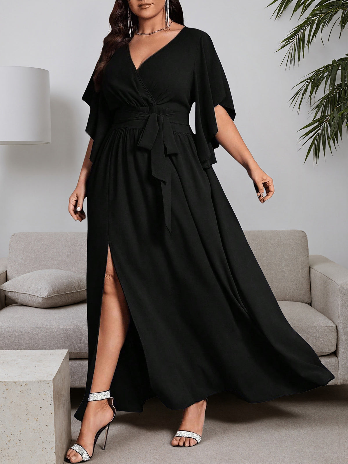Black plus-size maxi dress with V-neck wrap, tie waist, side slit, flutter sleeves