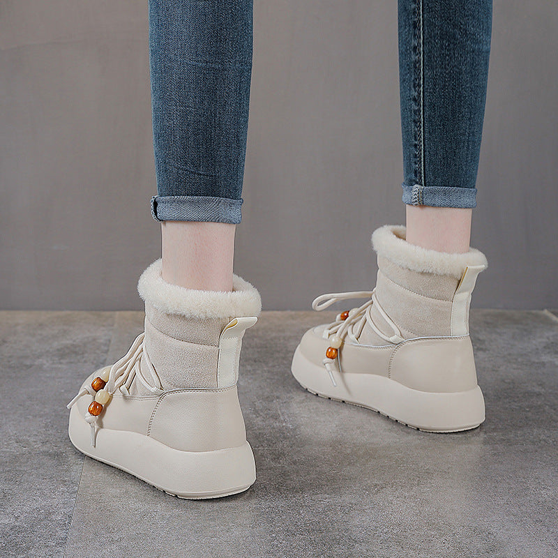 White ankle snow boots with lace ties, fuzzy cuff lining, and thick outsole