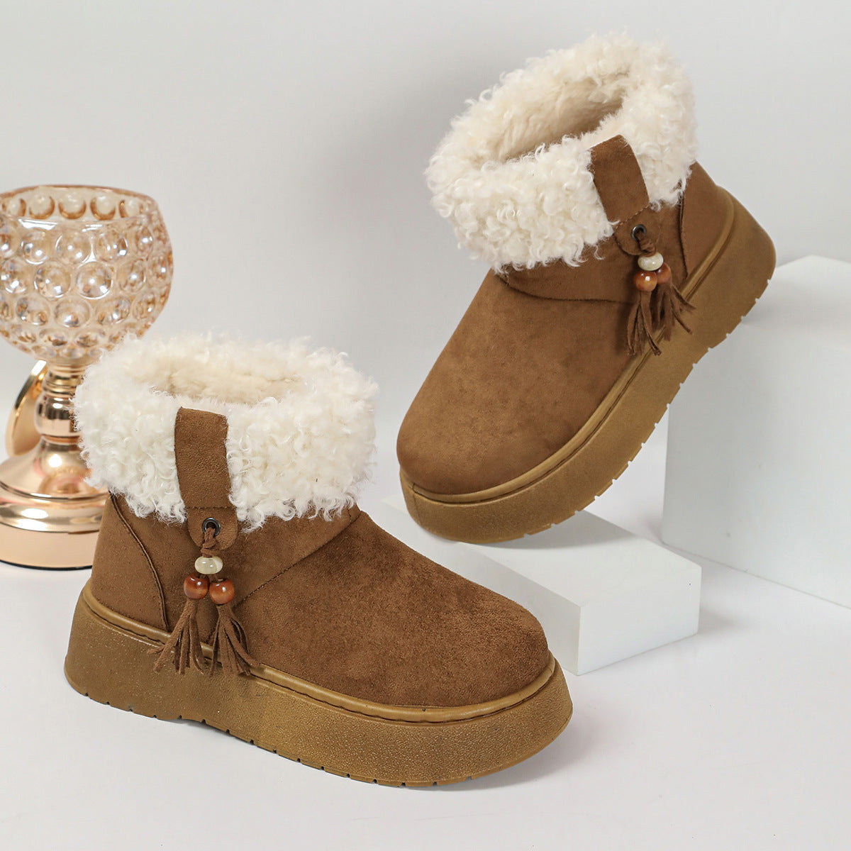 Brown suede winter boots with white faux-fur lining and tassel charm detail