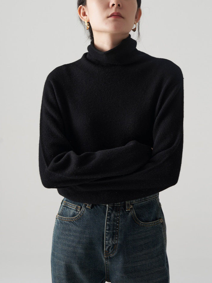 Black knit turtleneck sweater with high stack collar and long sleeves