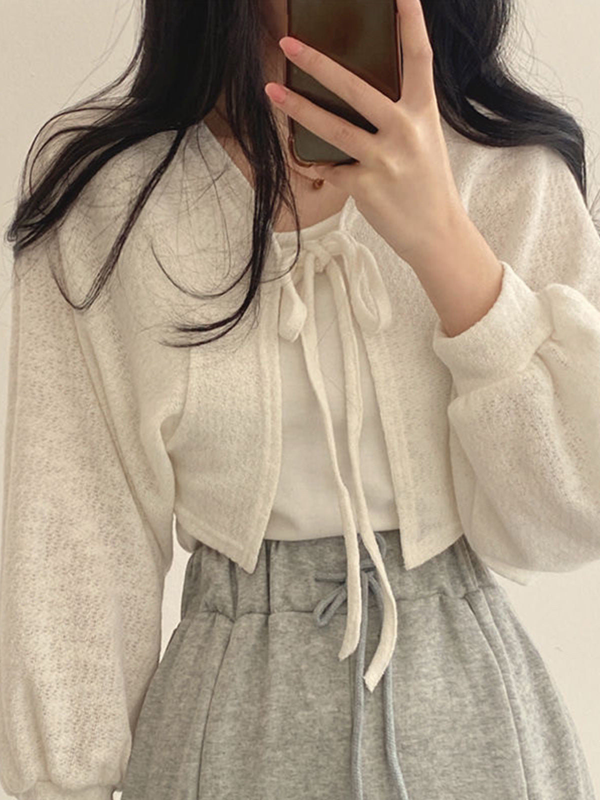 White cropped tie-front cardigan with long sleeves and bow neckline open knit bolero