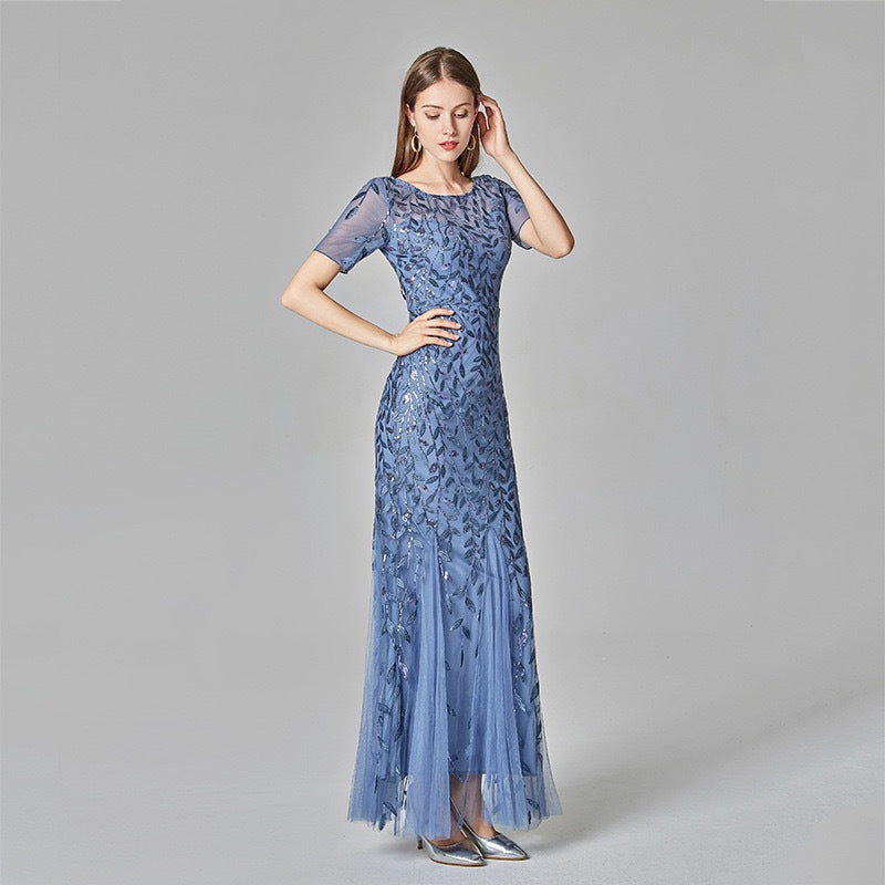 Light blue sequin mesh mermaid evening gown with short sleeves and layered tulle hem.