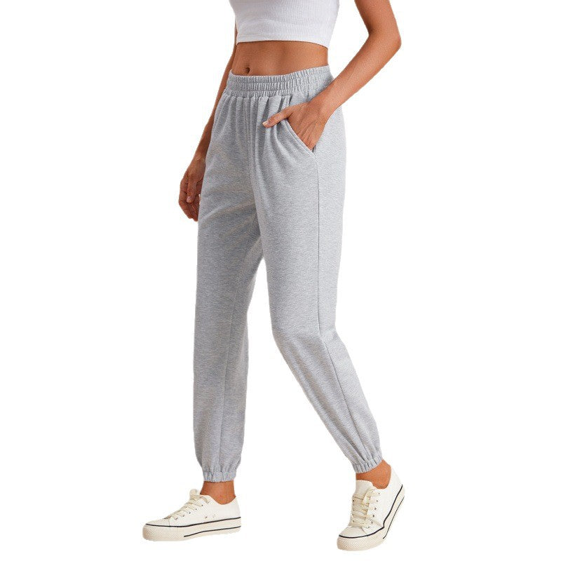 Grey high-waisted sweatpants with drawstring, elastic waistband, and gathered ankle cuffs