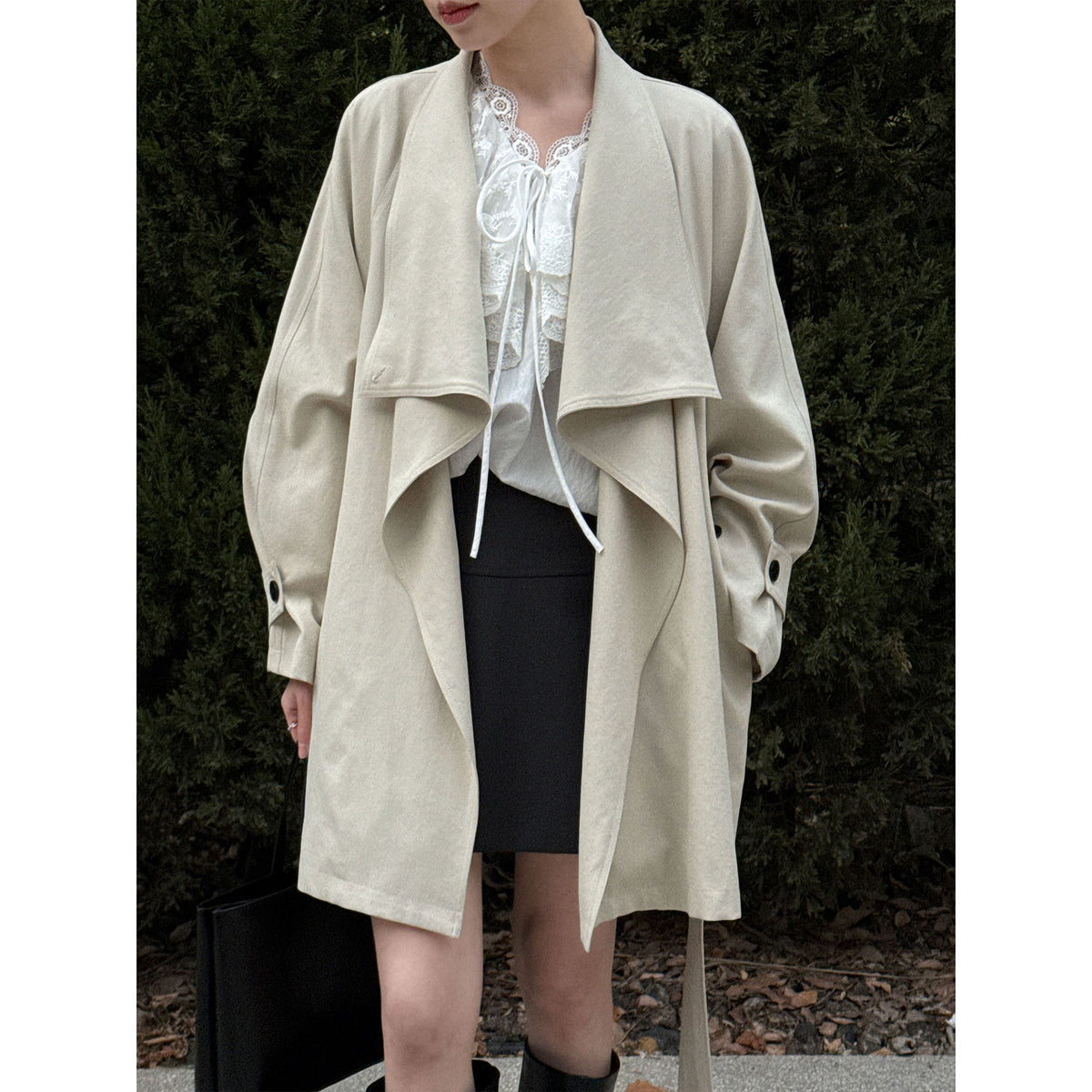 Women’s cream wrap coat with wide lapels, draped hem, and buttoned cuffs