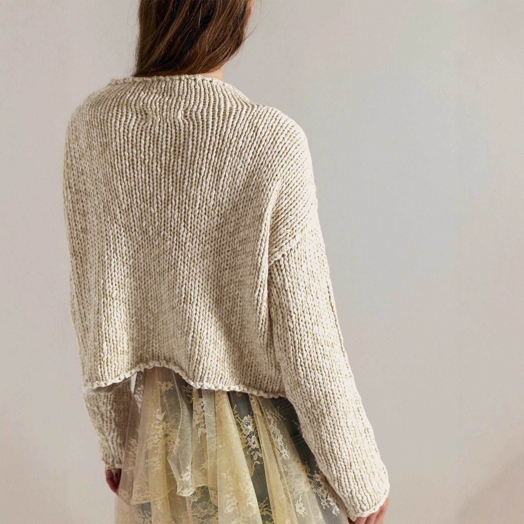 Women’s cream knit sweater, back view with long sleeves and curved hem
