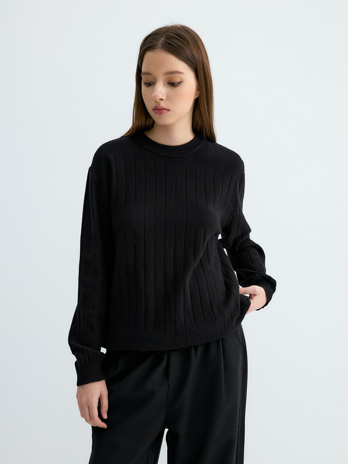 Black ribbed knit sweater with vertical stripes, round neck, loose fit sleeves.