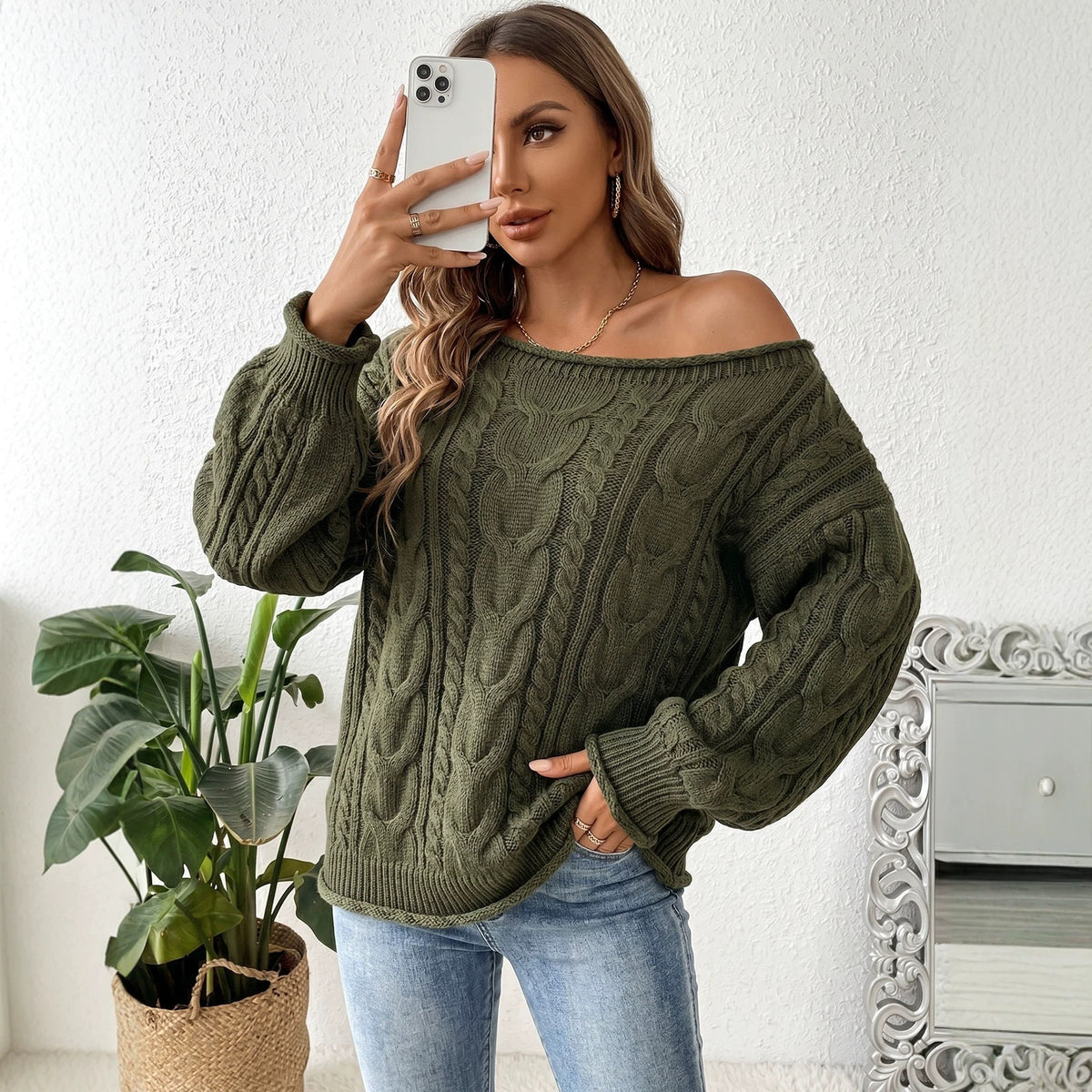 Olive green cable-knit sweater worn off one shoulder