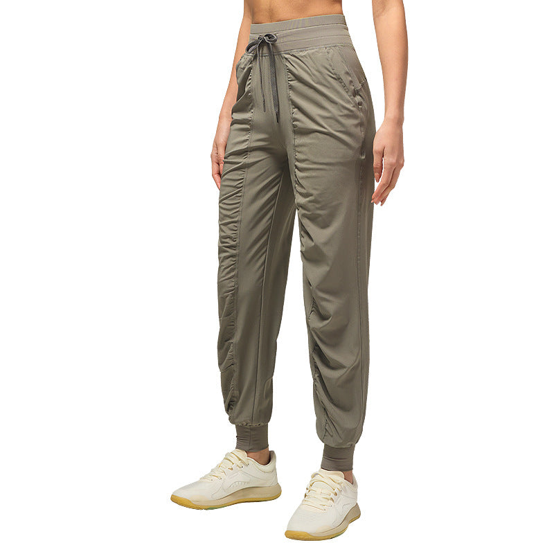 Women’s loose olive jogger pants with drawstring waist and cuffed ankles, side pockets.