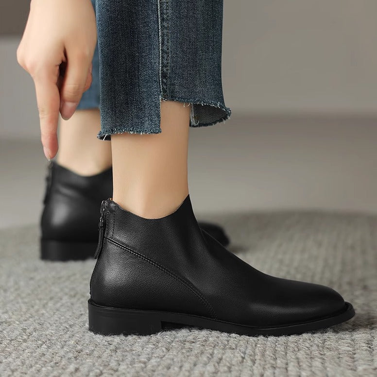 Women’s black short ankle boots with side seam zipper and low block heel.