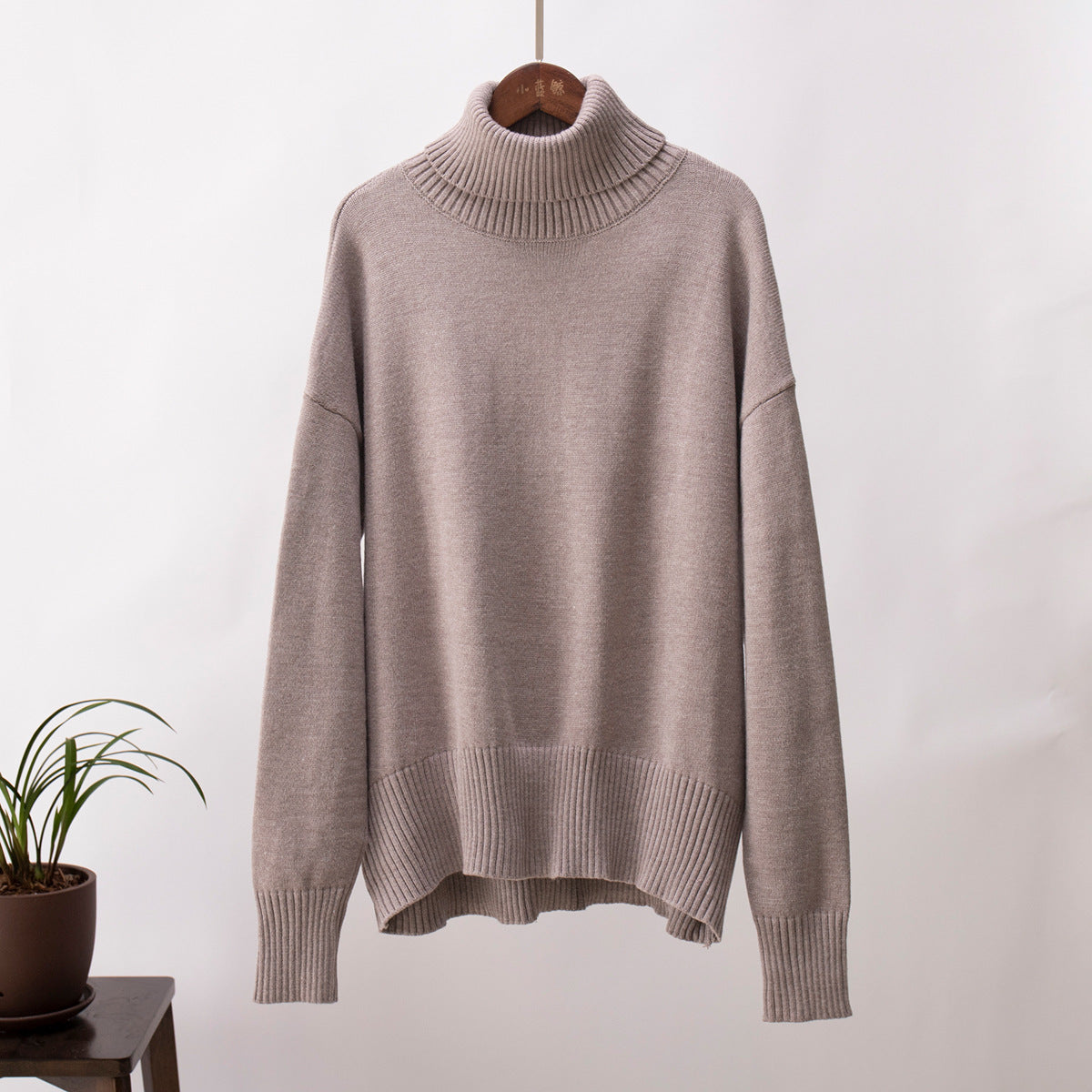 Light taupe knit turtleneck pullover sweater with loose fit and ribbed cuffs