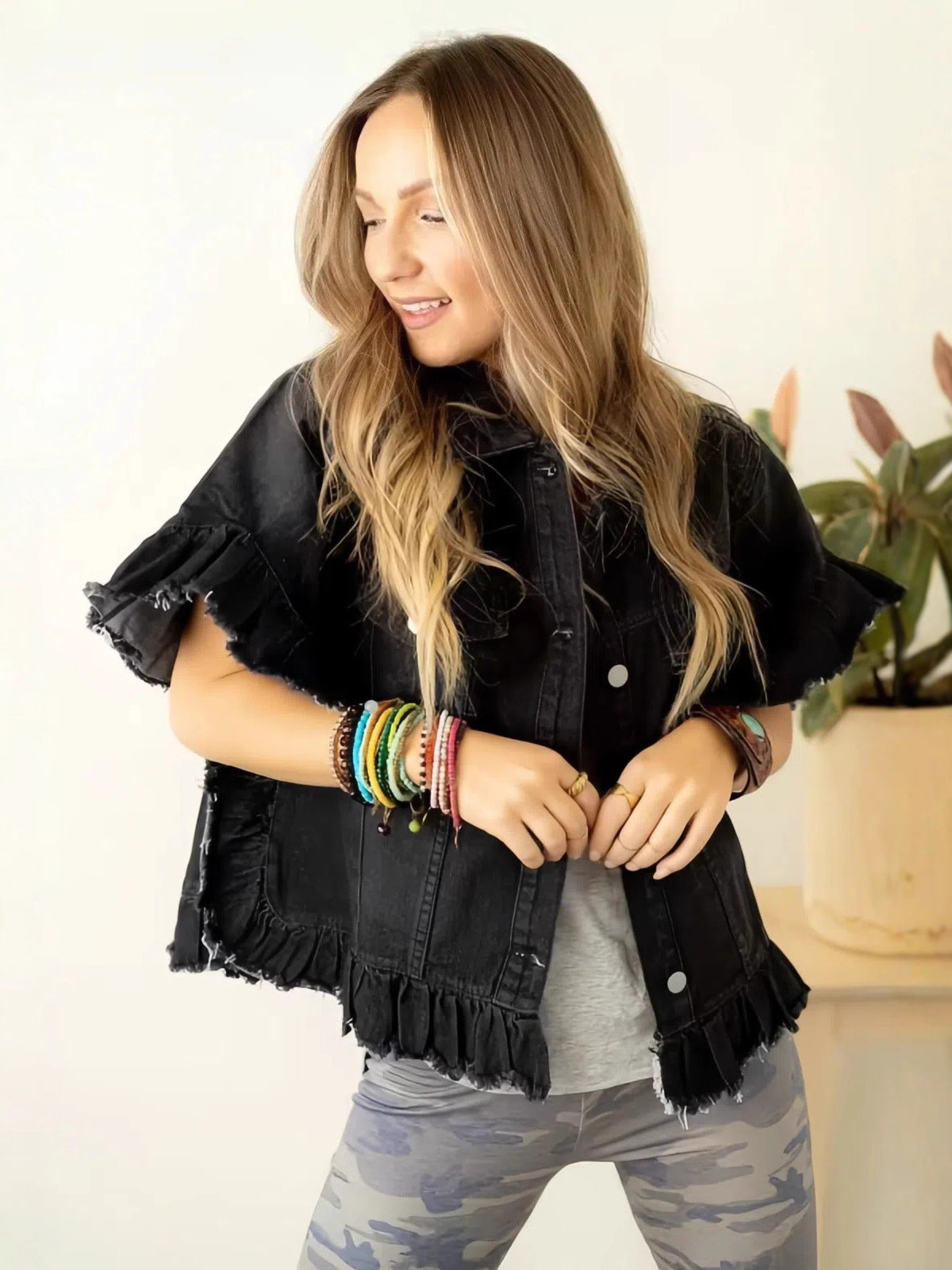 Women's black denim top with button front, ruffled sleeves, and frayed hem