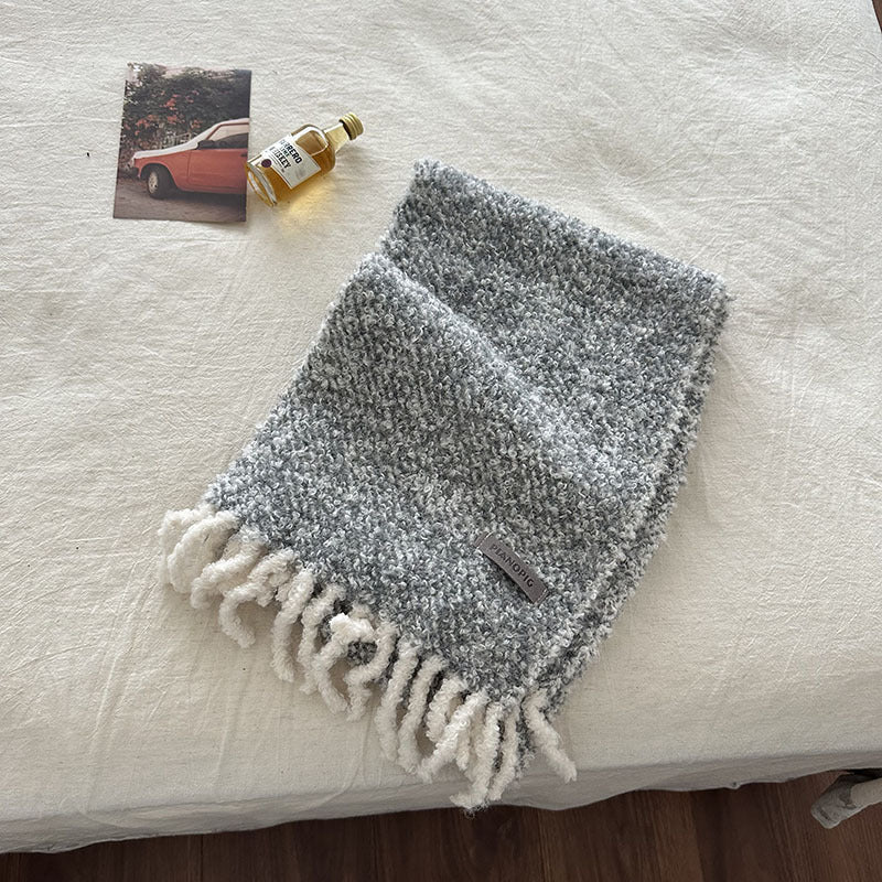 Light gray chunky loop-knit scarf shawl with white fringed bottom and small label
