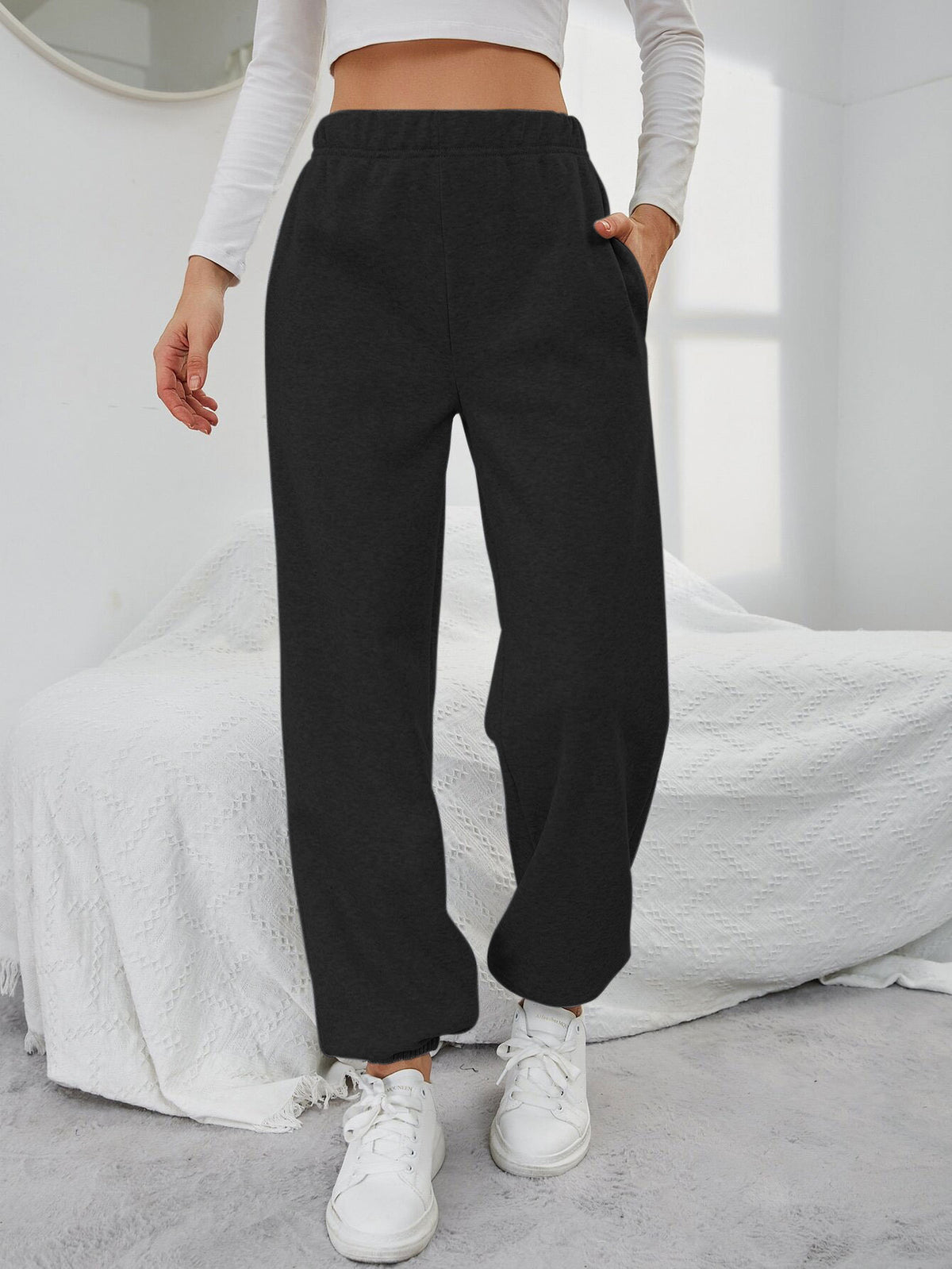 Black high-waisted straight-leg sweatpants with side pockets and elastic waistband