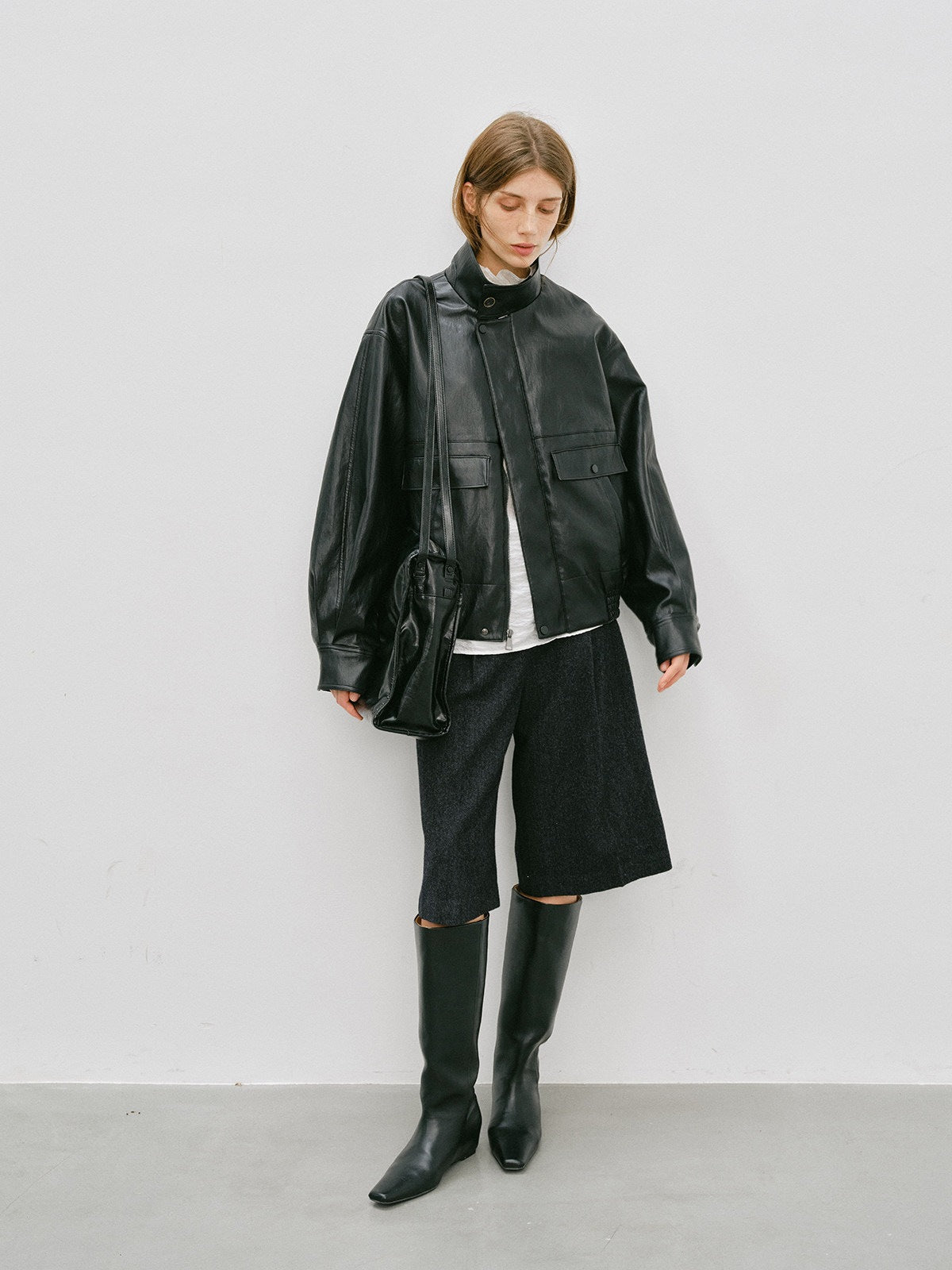 Black PU leather jacket with stand-up collar and flap chest pockets, relaxed silhouette