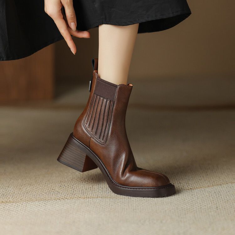 Women's brown ankle boots with elastic side gore and blocky mid heel.