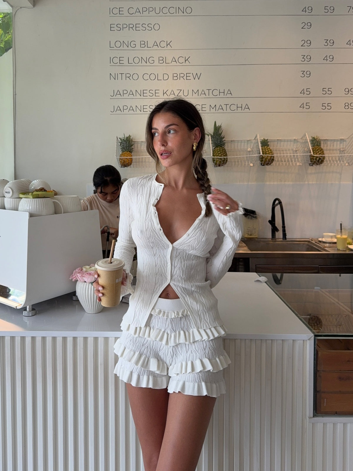 White long-sleeve knitted cardigan with layered ruffle hem, front view