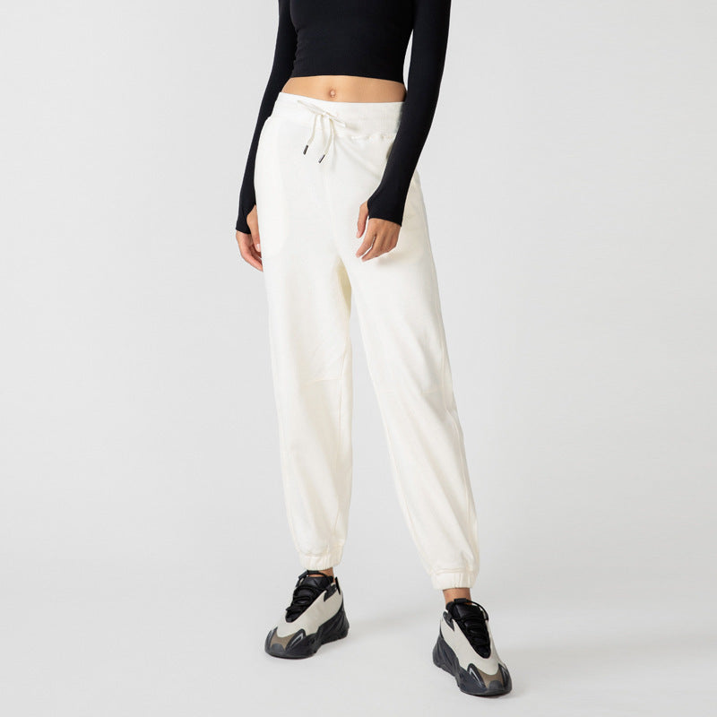 Ivory jogger pants with drawstring waist, side pockets, and elastic ankle cuffs