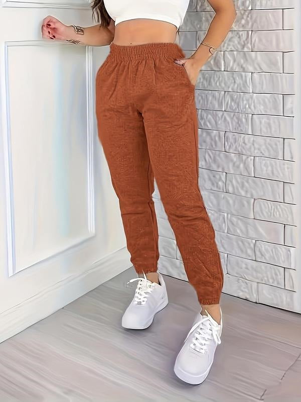 Orange women's jogger pants with elastic waistband and tapered ankle cuffs