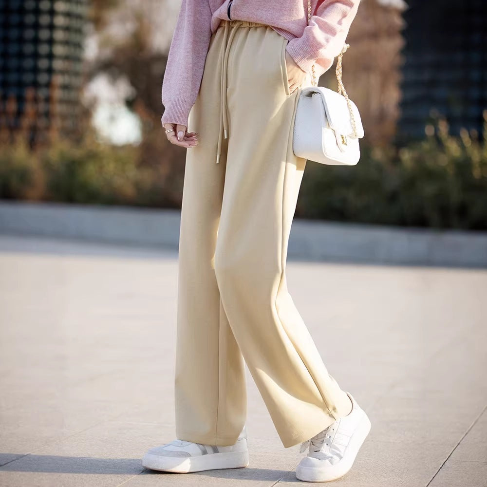Women’s light cream wide-leg pants with elastic waist ties and flowy straight-leg drape