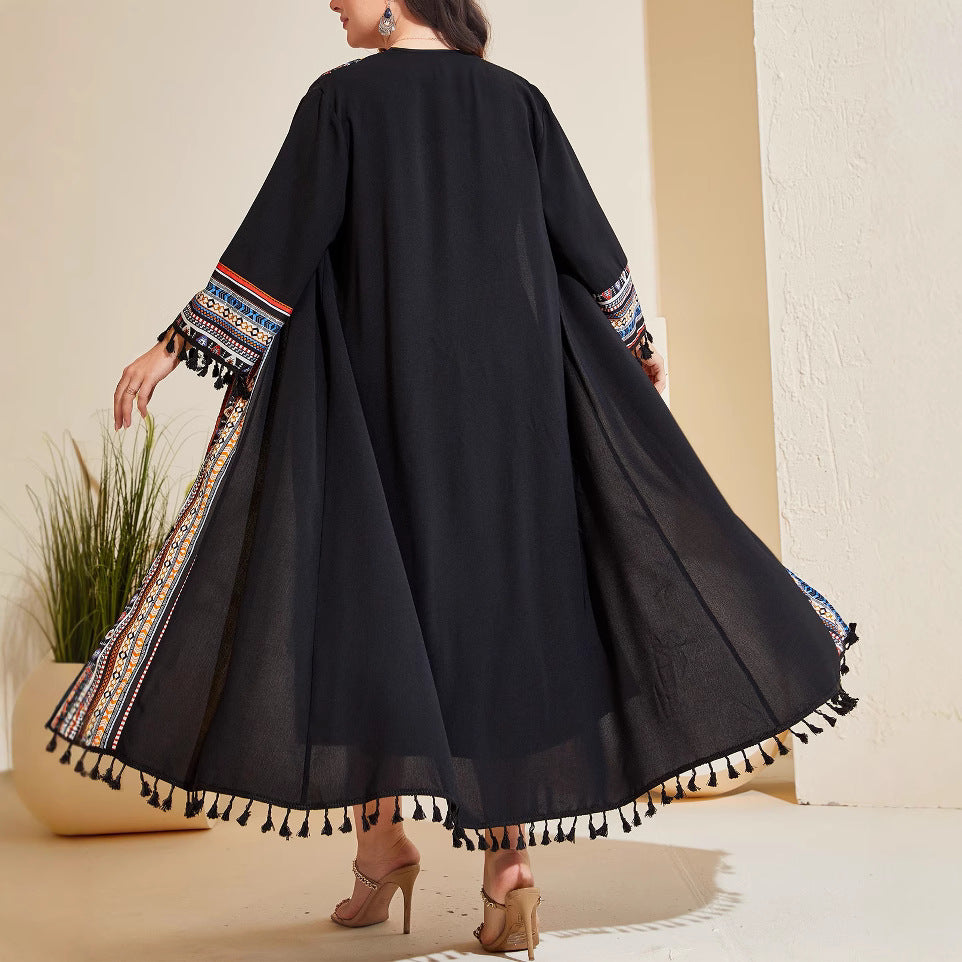 Black long cardigan back view with vertical patterned trim and tassel-trim flare hem