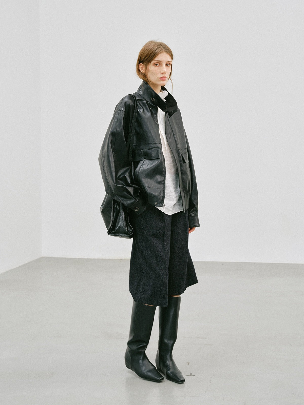 Black PU leather workwear jacket with stand-up collar, side view, flap pockets