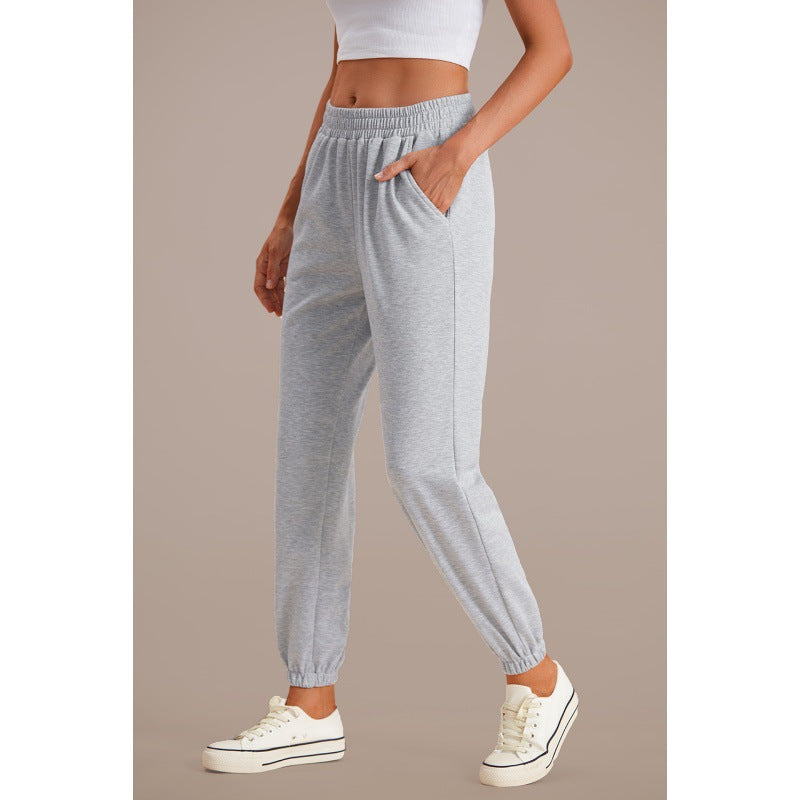 Grey high-waisted jogger sweatpants with elastic waistband, drawstring, and tapered cuffs
