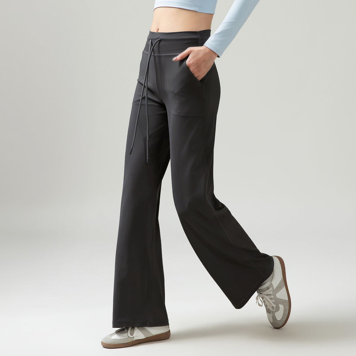 Women’s high-waisted wide-leg pants with drape, dark gray, side drawstring ties and pockets.