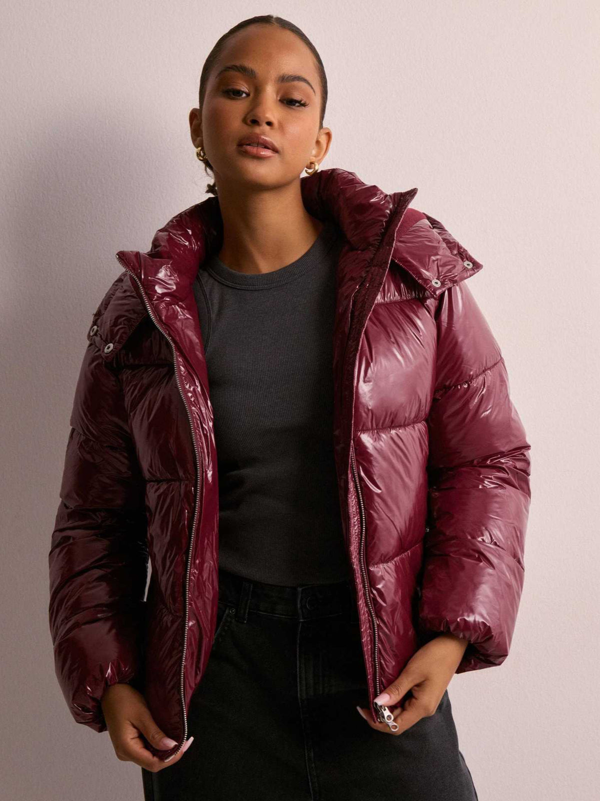 Shiny burgundy puffer jacket with oversized hood, quilted panels, front zipper