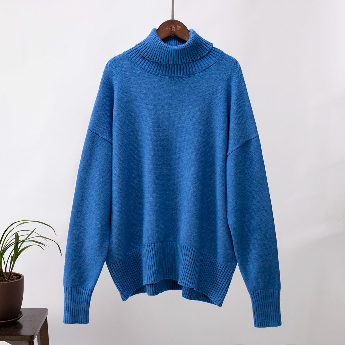 Blue knit turtleneck pullover sweater with loose fit, ribbed cuffs and hem detail