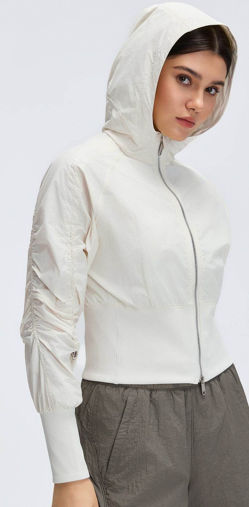 White cropped hooded zip-up windbreaker with cinched ribbed waist and front zipper