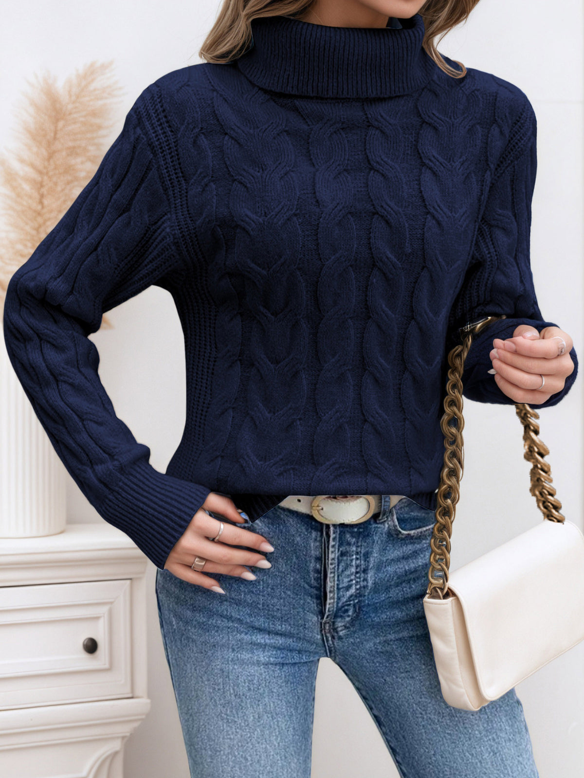Navy knit turtleneck sweater with long sleeves and cable twist texture